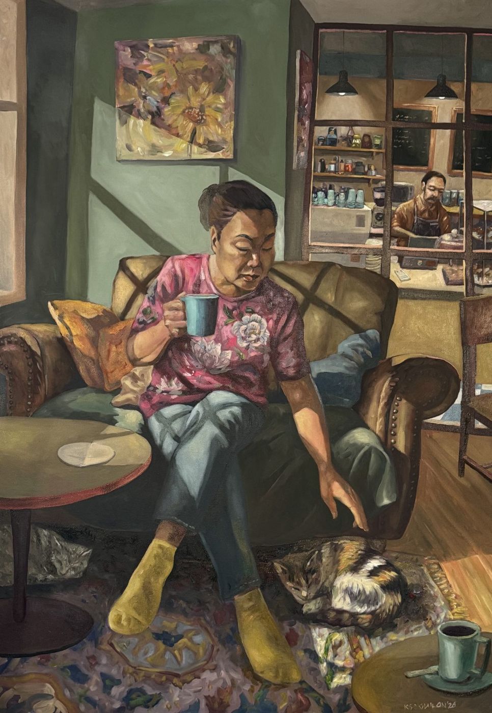 Oil painting of a woman on a leather sofa holding a blue mug and reaching down to a sleeping cat, a café counter behind – Kris Soguilon